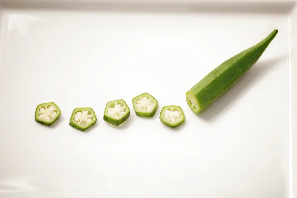 A Lady's finger (okra) and its pieces on the table