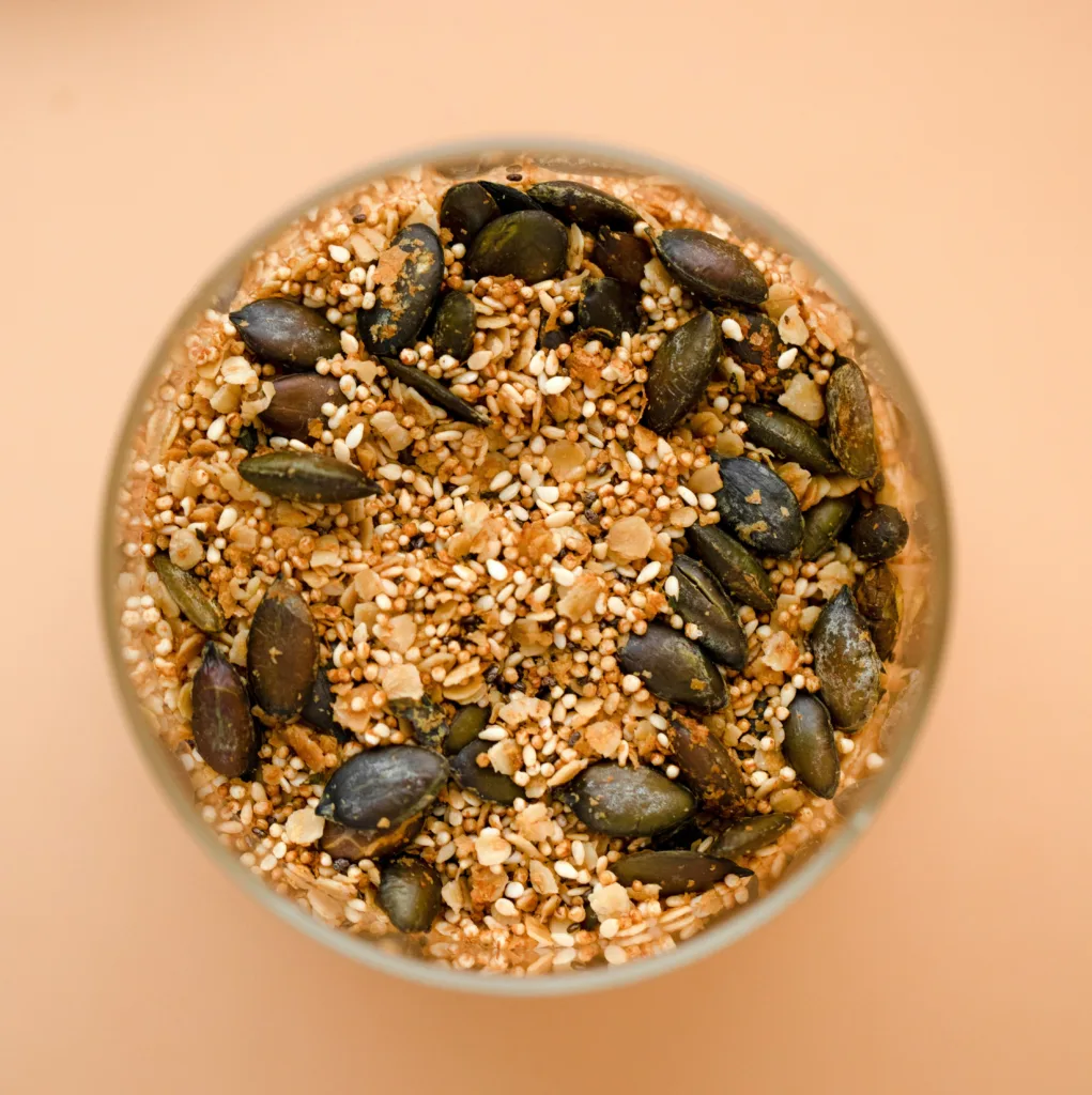 A glass bowl filled with seeds on top of a table