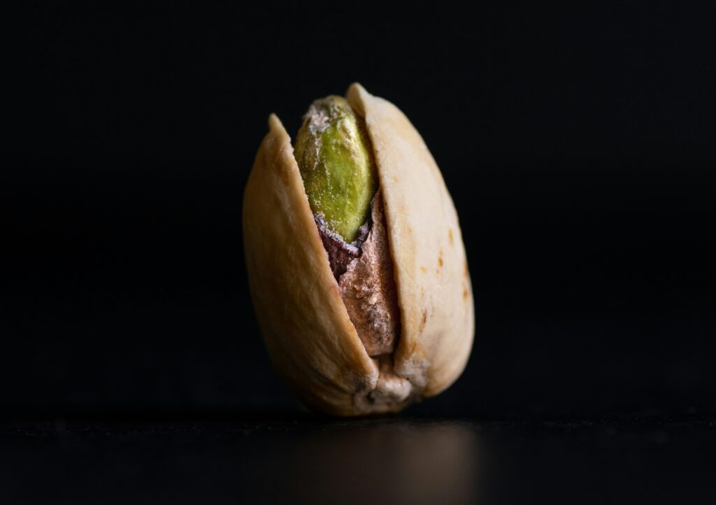 a whole pistachio in a black background