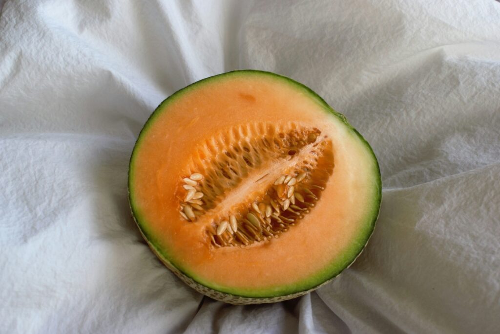 A half piece of cantaloupe on a white cloth